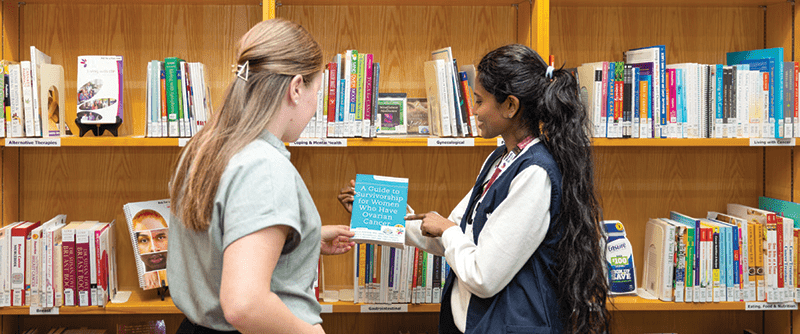 A volunteer helping a team member in the library.
