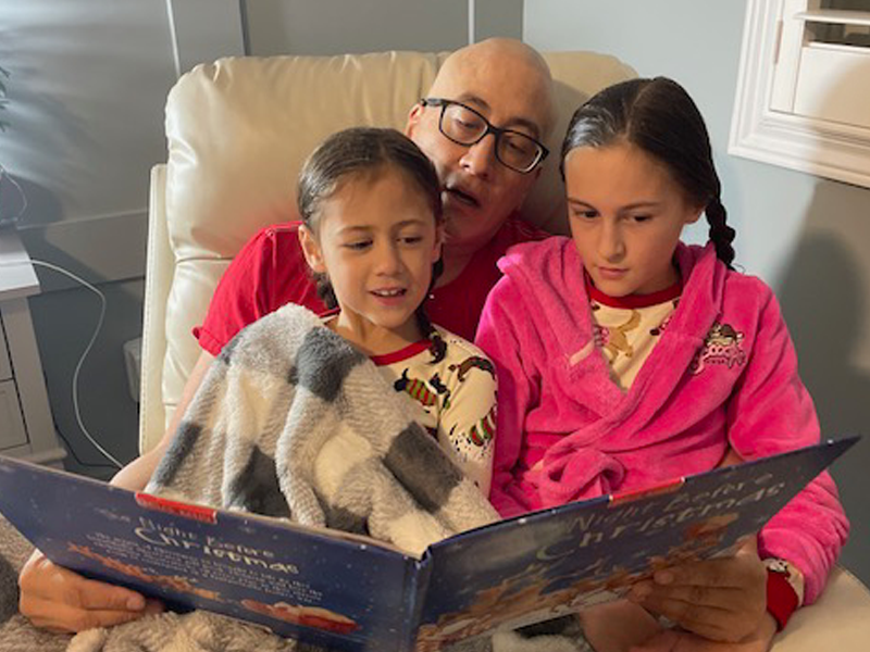 Photo: Jonathan Uyede reading The Night Before Christmas to his daughters.