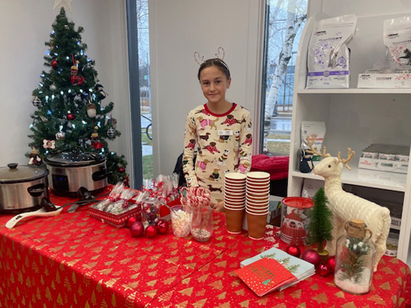 Photo: Nyah selling handmade Christmas cards, hot cocoa, candy canes and apple cider at a stand at her dad’s veterinary clinic.